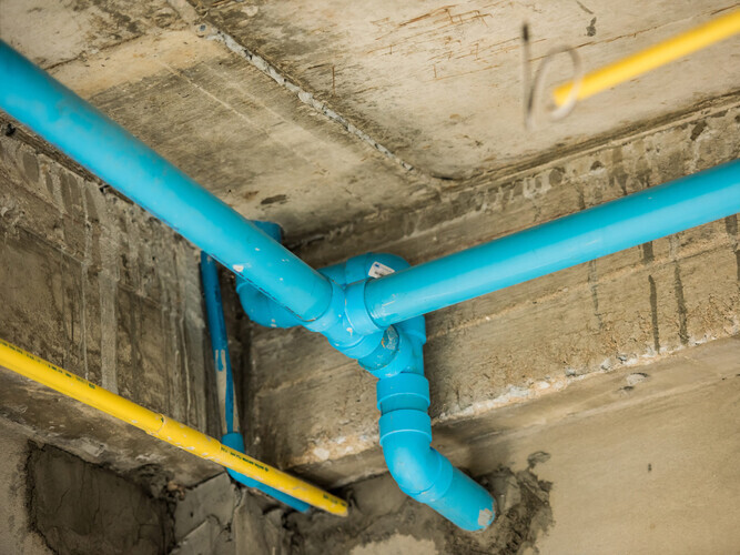 Blue PVC pipe under the structure of a house
